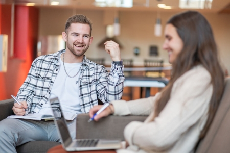 students sitting with a computer in a student lounge