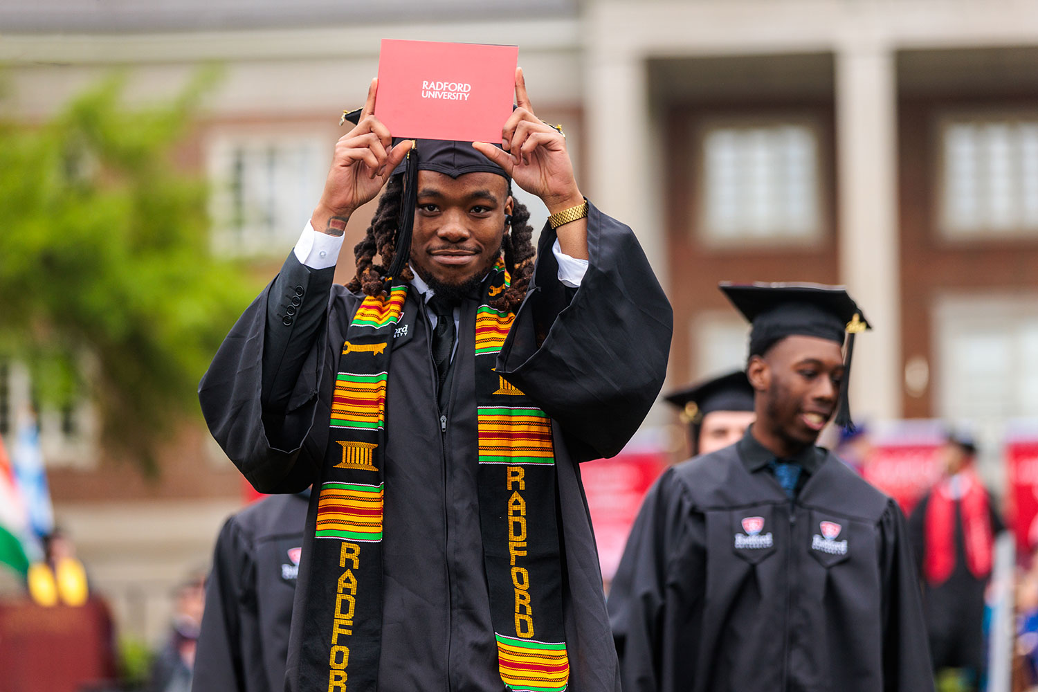 Student showing off diploma after walking across stage