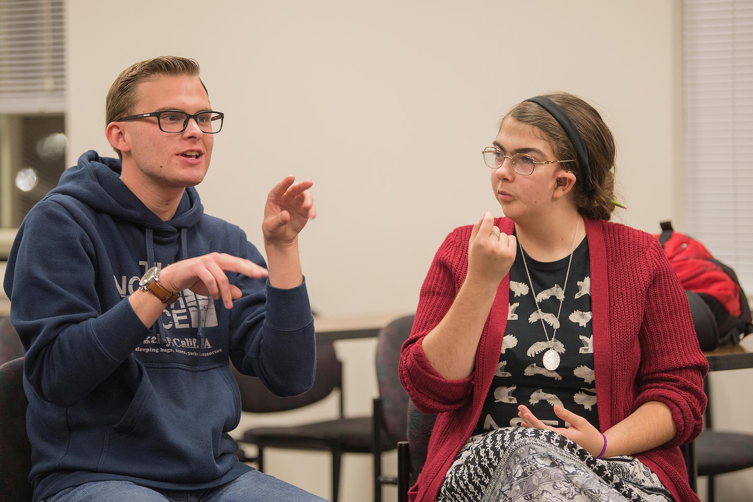 two students speaking through sign language