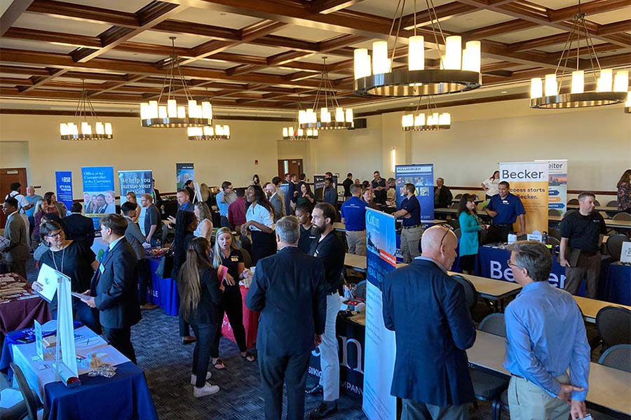 Numerous students and faculty members meet with company representatives and potential employers in Kyle Hall's large conference room.