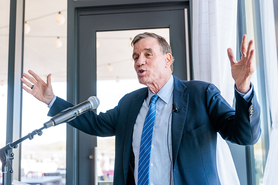 Senator Mark Warner speaks to guests during a luncheon at The Highlander Hotel.