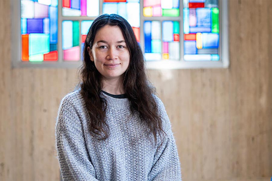 Female student in front of stained glass window