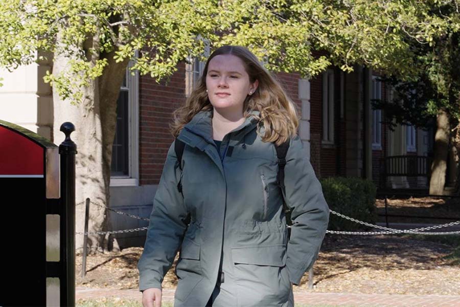 A graphic design student heads across Radford University's campus near Walker Hall