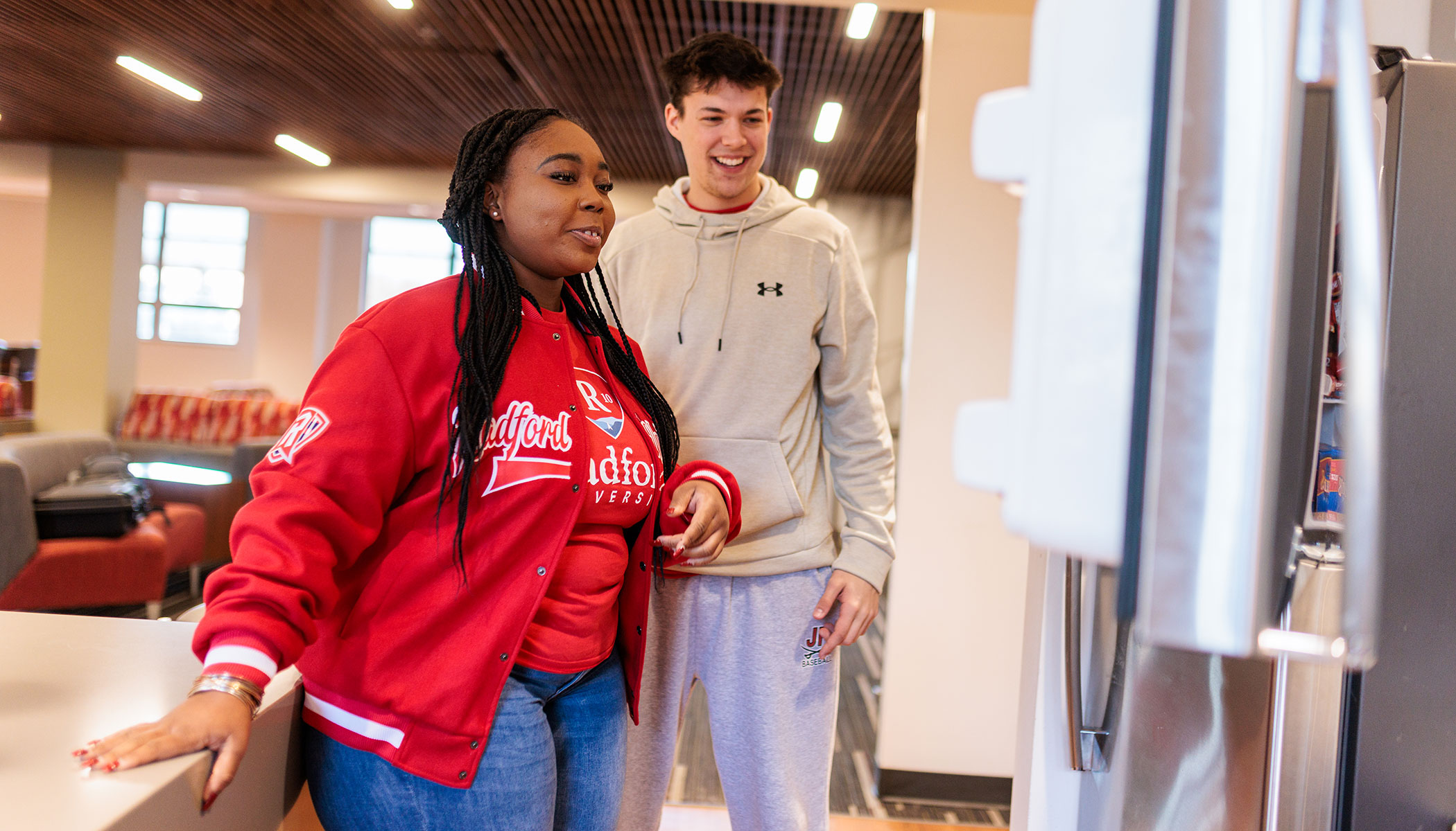 Students looking into a shared refrigerator on campus.