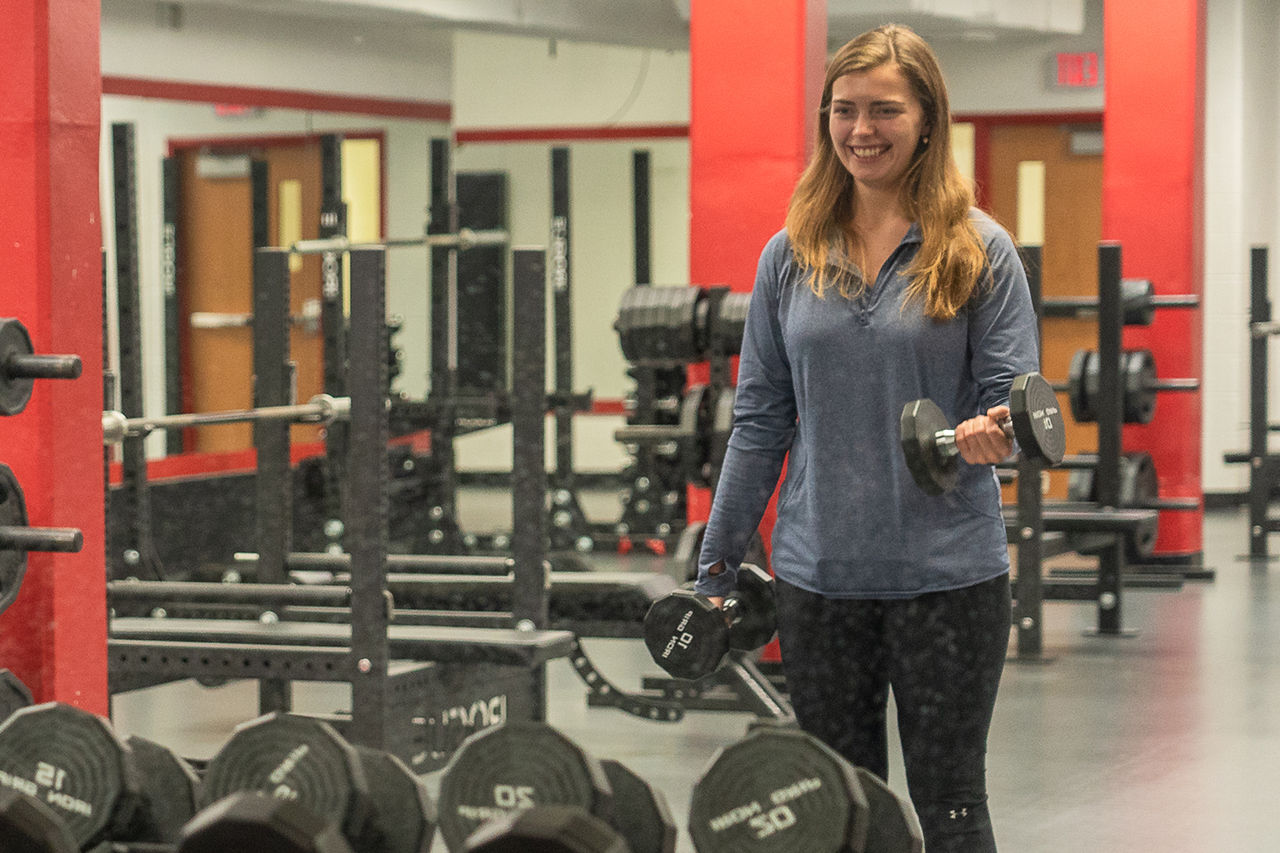 students lifting weight in gym