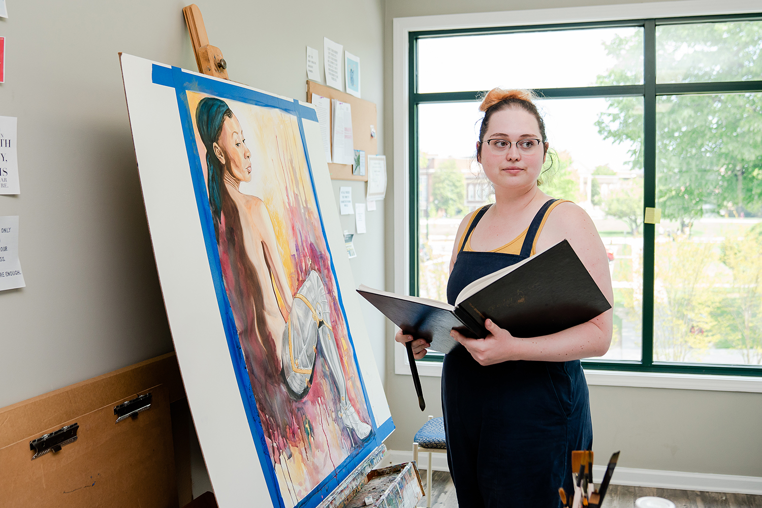 student standing next to a painting