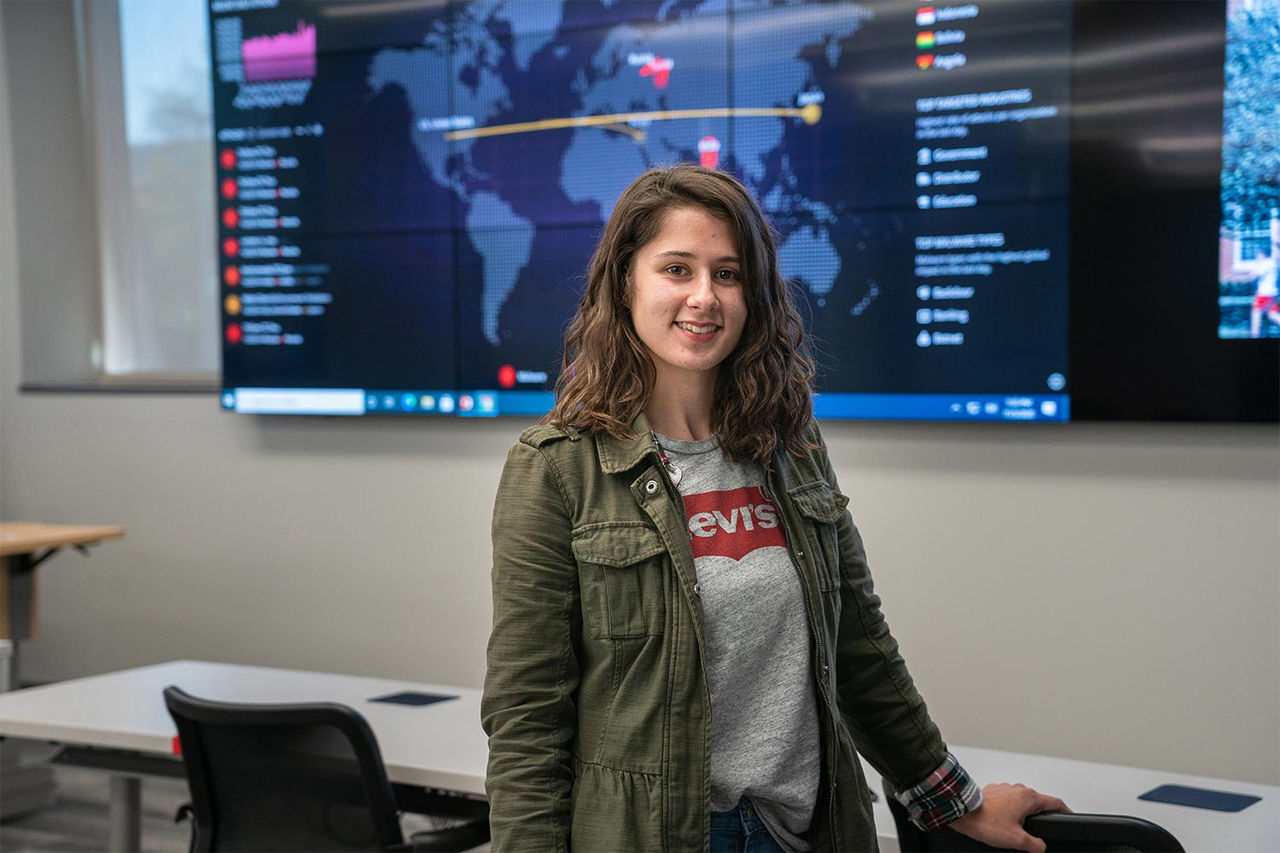 A girl standing in front of a security screen in a casual outfit