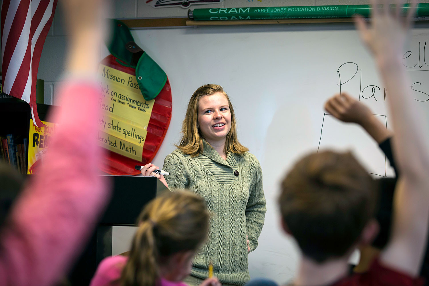 view of a teacher from a student perspective in back of classroom