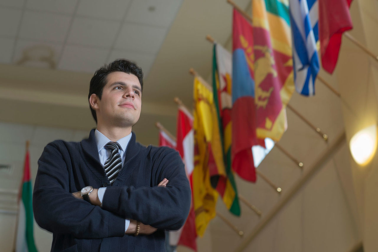 man standing with flags at the back 