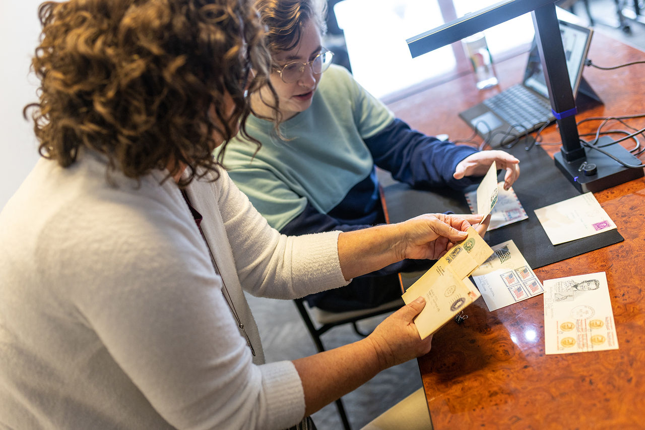 two students looking at old stamps together