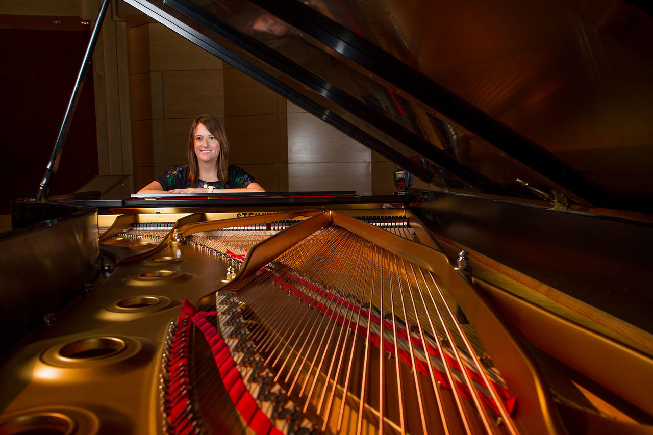 a female sitting at a piano