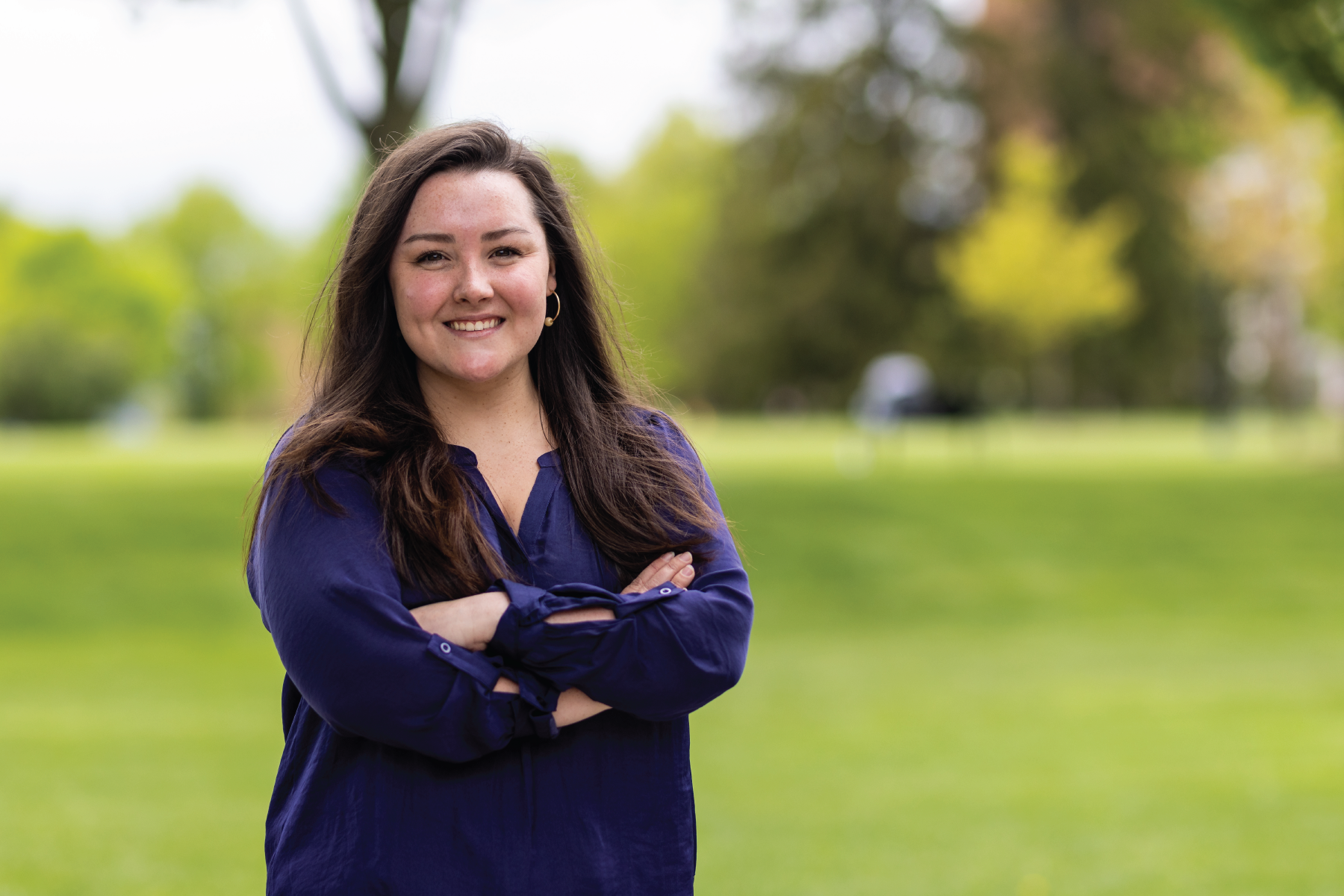 rachel warren, arms folded with a natural background smiling at the camera