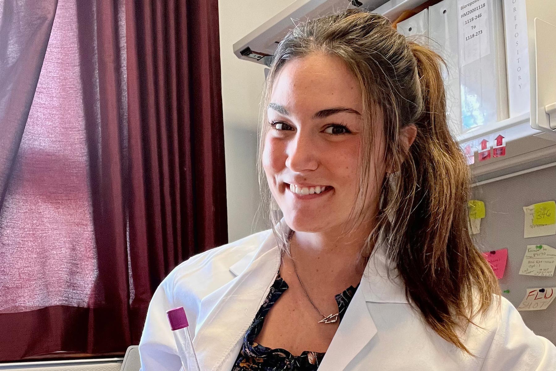 Anna Kate Draper smiling while in a white lab coat