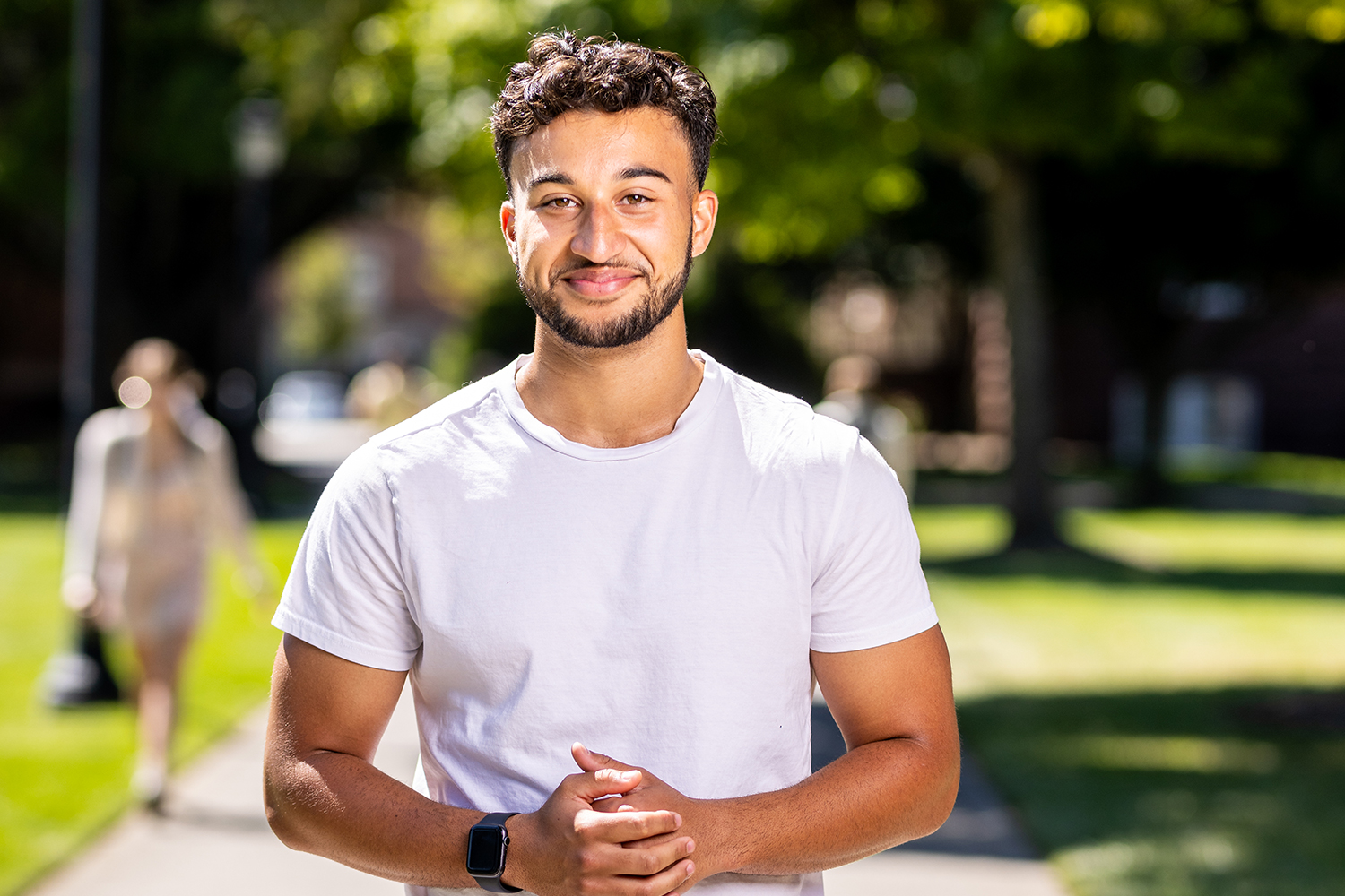 student on campus stops for a photo