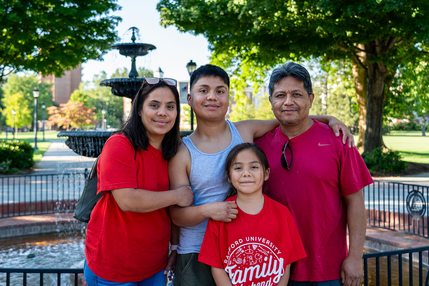 A family standing on campus with their Highlander.