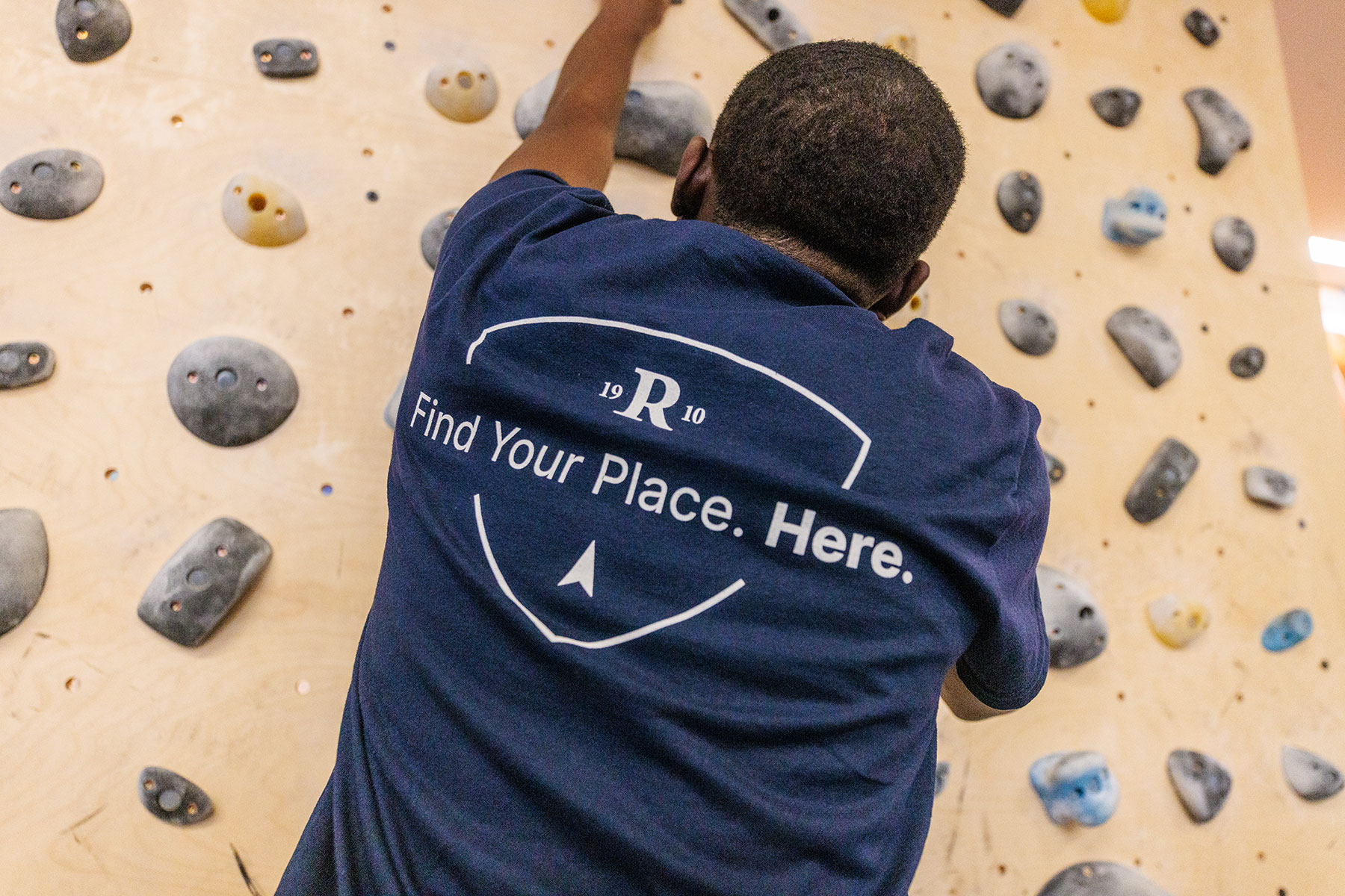 student climbing the rock wall